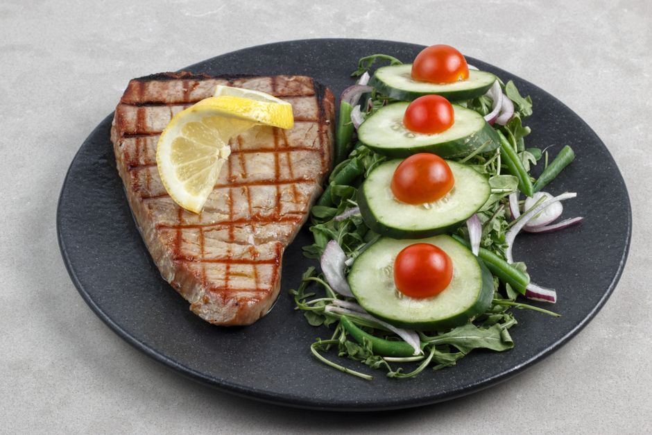 Delicious grilled tuna steak served with fresh cucumber and cherry tomato salad. Perfect for healthy eating.