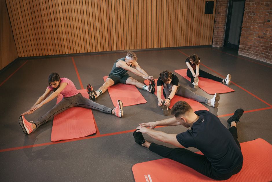 Adults in a yoga studio stretch on mats, promoting fitness and flexibility.
