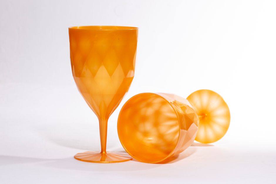 Two orange goblets on a white surface create a chic, minimalist look with strong contrast.